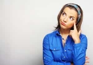 Woman looking up in the air with her finger on her head (thinking)(